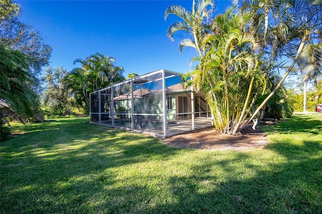 view of yard featuring glass enclosure and a patio