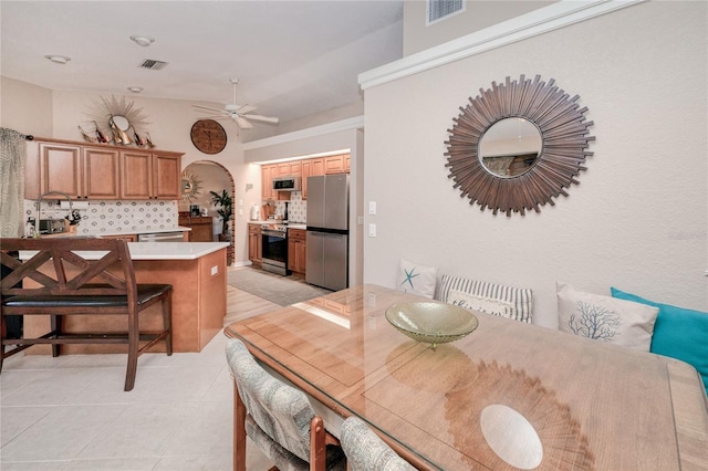 tiled dining space with ceiling fan