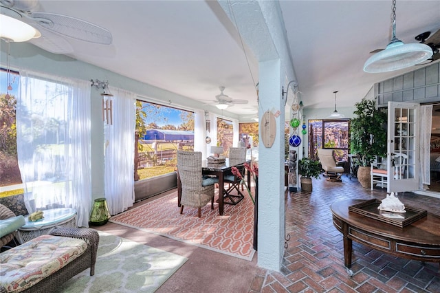 sunroom / solarium featuring ceiling fan, french doors, and lofted ceiling