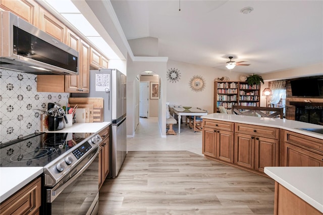 kitchen featuring stainless steel appliances, light hardwood / wood-style flooring, tasteful backsplash, and ceiling fan