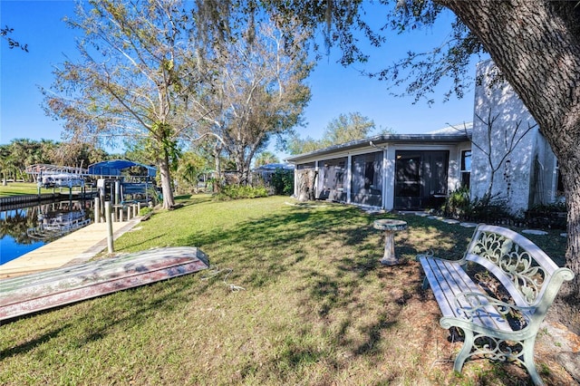 view of yard with a sunroom and a dock