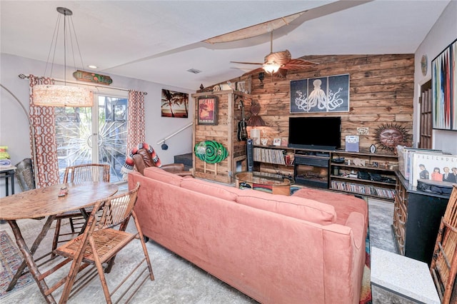 living room featuring ceiling fan, wood walls, carpet floors, vaulted ceiling, and a fireplace