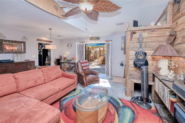 living room with carpet, a wood stove, and ceiling fan