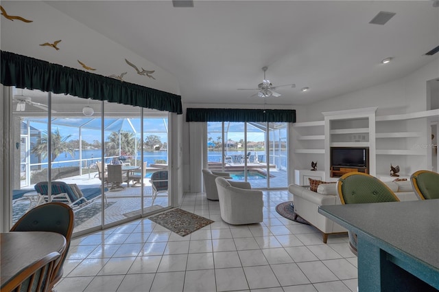 living room with light tile patterned floors, vaulted ceiling, ceiling fan, and built in shelves