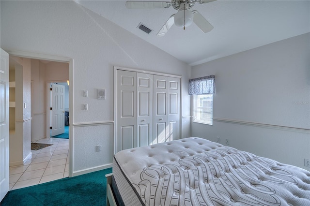 tiled bedroom with vaulted ceiling, a closet, and ceiling fan