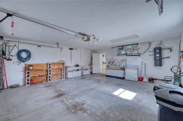 garage with a workshop area, white refrigerator, and a garage door opener