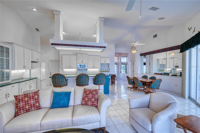 tiled living room featuring high vaulted ceiling and ceiling fan