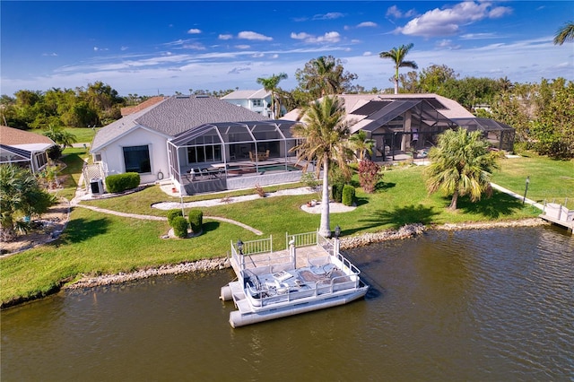 rear view of house with a lanai, a yard, and a water view