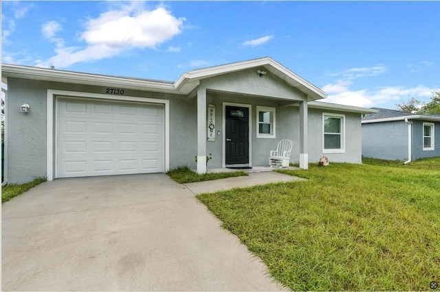 ranch-style home featuring a garage and a front lawn