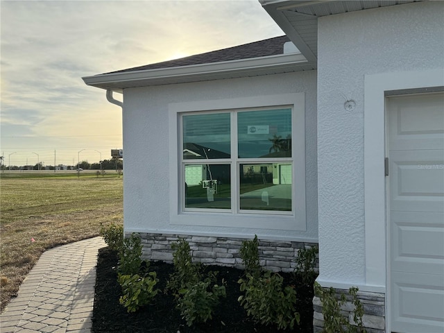 property exterior at dusk featuring a yard