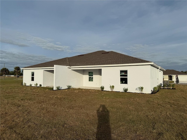 rear view of property featuring a lawn