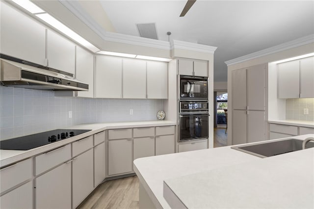 kitchen with white cabinets, light wood-type flooring, black electric cooktop, and backsplash