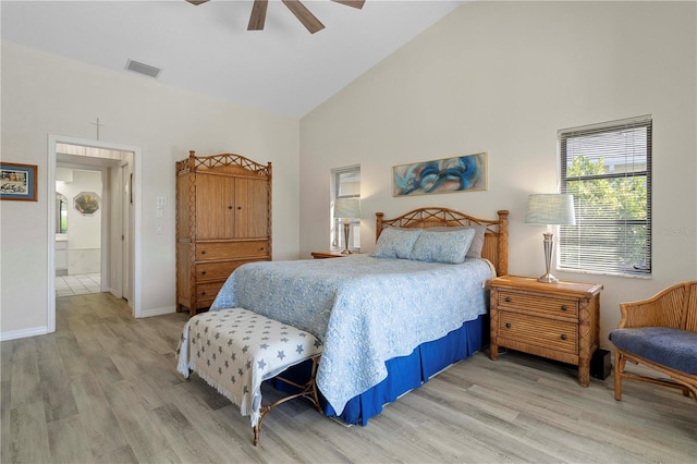 bedroom featuring hardwood / wood-style floors, high vaulted ceiling, ensuite bath, and ceiling fan