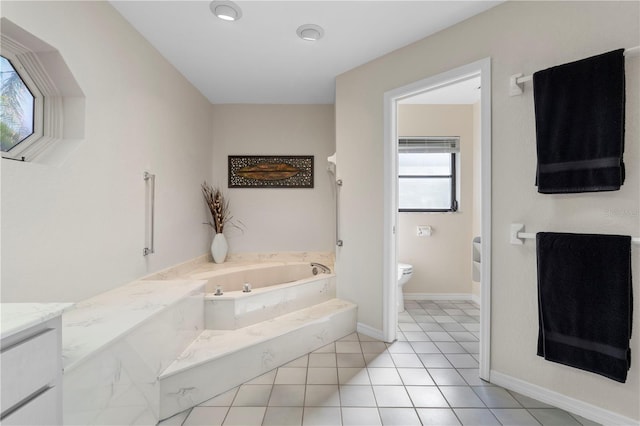 bathroom featuring a washtub, tile patterned flooring, vanity, and toilet