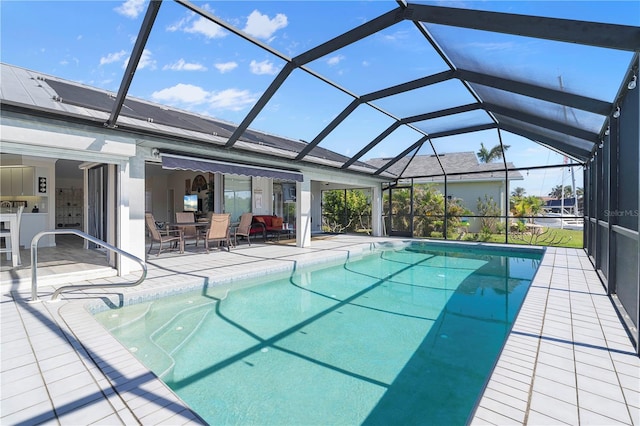 view of pool with a patio area and glass enclosure