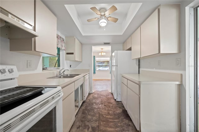 kitchen with sink, ceiling fan with notable chandelier, a raised ceiling, and white appliances