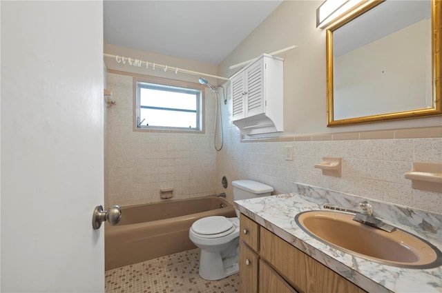 full bathroom featuring toilet, tiled shower / bath, tile patterned flooring, tile walls, and vanity