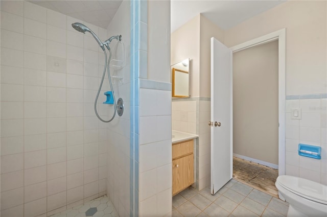 bathroom featuring vanity, tile walls, tile patterned floors, and tiled shower