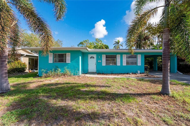 single story home with a front lawn and a carport