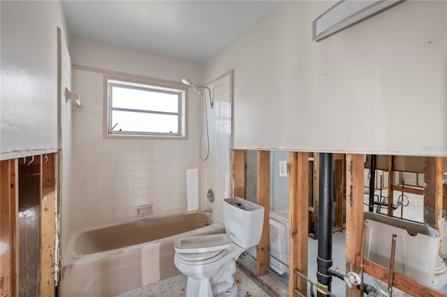 bathroom featuring toilet and tiled shower / bath