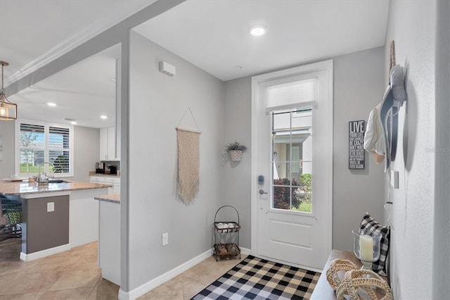 tiled foyer entrance featuring sink and a wealth of natural light