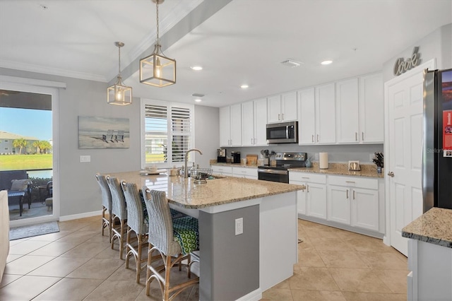 kitchen featuring white cabinetry, sink, stainless steel appliances, an island with sink, and decorative light fixtures