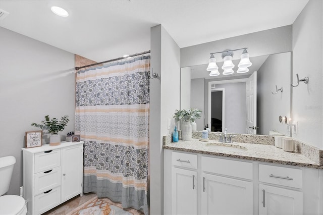 bathroom with vanity, a shower with shower curtain, and toilet