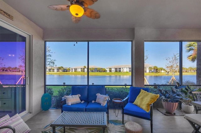 sunroom / solarium featuring ceiling fan and a water view