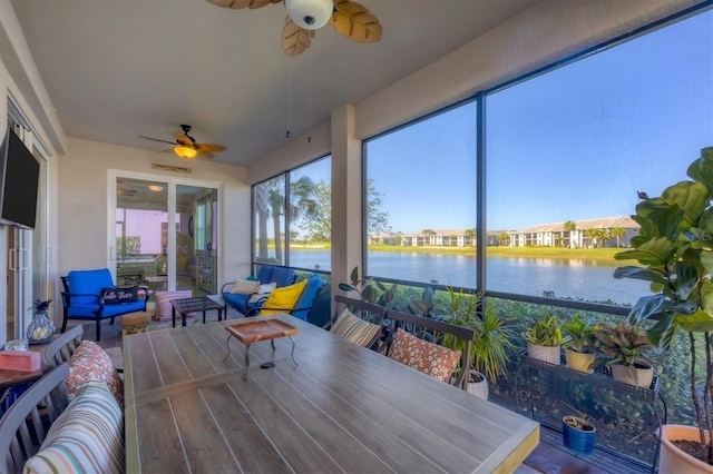 sunroom / solarium with a water view and ceiling fan