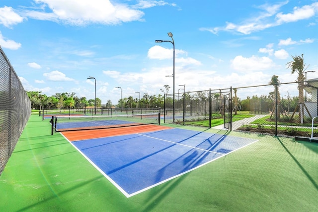 view of tennis court with basketball hoop