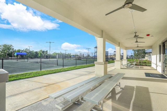 view of patio featuring ceiling fan and tennis court