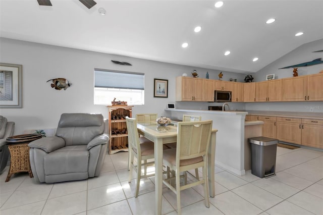 tiled dining space featuring vaulted ceiling