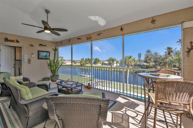 sunroom / solarium with ceiling fan and a water view