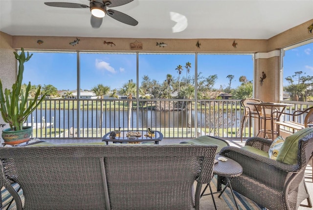 interior space with a water view, ceiling fan, and a balcony