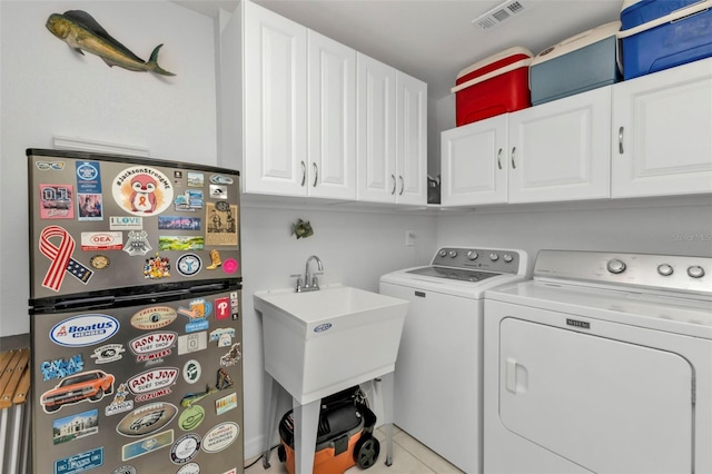 laundry area featuring light tile patterned flooring, cabinets, independent washer and dryer, and sink