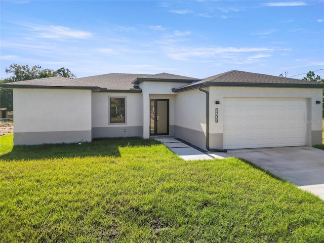 view of front of home with a front yard and a garage