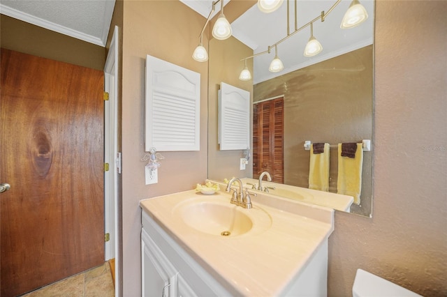 bathroom with tile patterned flooring, vanity, a textured ceiling, and ornamental molding