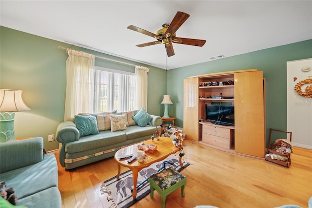 living room featuring wood-type flooring and ceiling fan