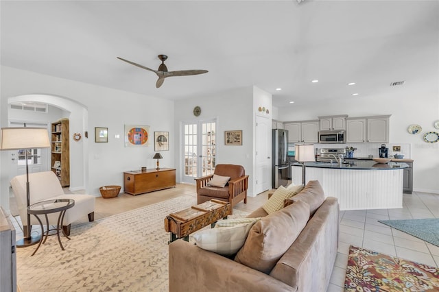 living room featuring ceiling fan, light tile patterned floors, and sink