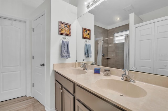 bathroom with hardwood / wood-style floors, vanity, and a shower with shower door