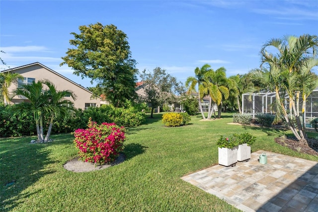 view of yard featuring glass enclosure and a patio