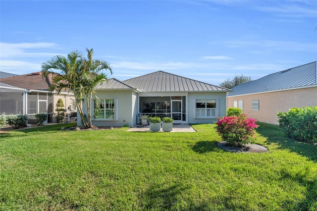 rear view of property featuring a sunroom and a yard