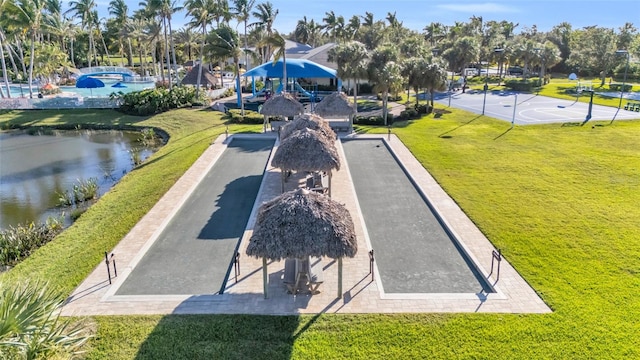 view of community featuring a yard, a water view, and basketball court