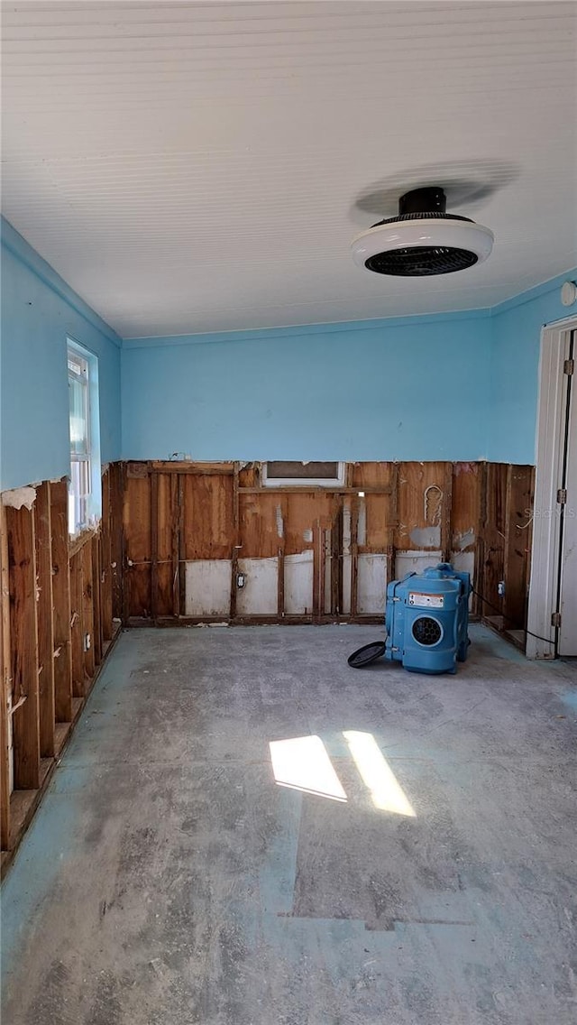 misc room featuring concrete floors and wood walls