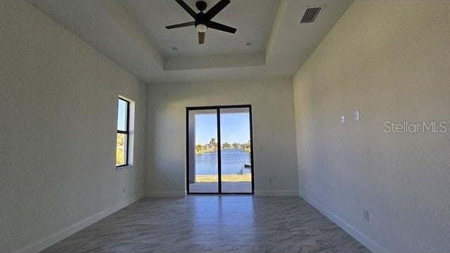 spare room featuring a tray ceiling and ceiling fan