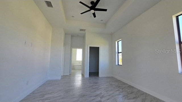 unfurnished room with a tray ceiling and ceiling fan