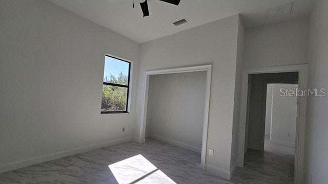 unfurnished bedroom with ceiling fan and lofted ceiling