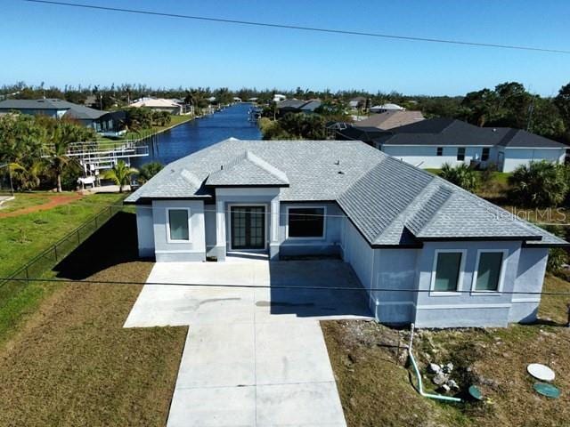 view of front of property featuring a water view and a front lawn