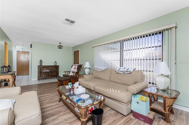 living room with a textured ceiling and light hardwood / wood-style floors