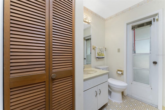 bathroom with tile patterned flooring, vanity, and toilet